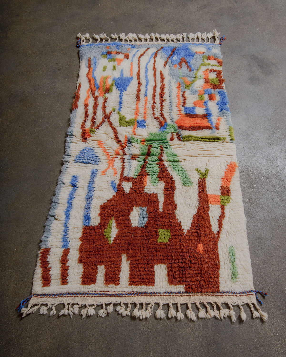 Colorful woven rug with abstract patterns on a gray floor